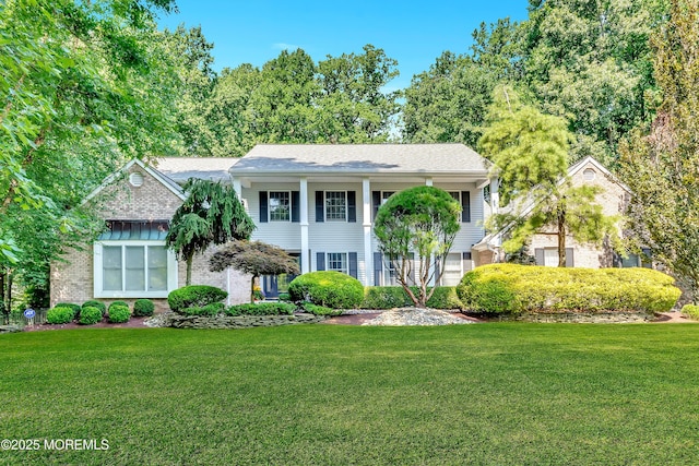 view of front of house featuring brick siding and a front yard