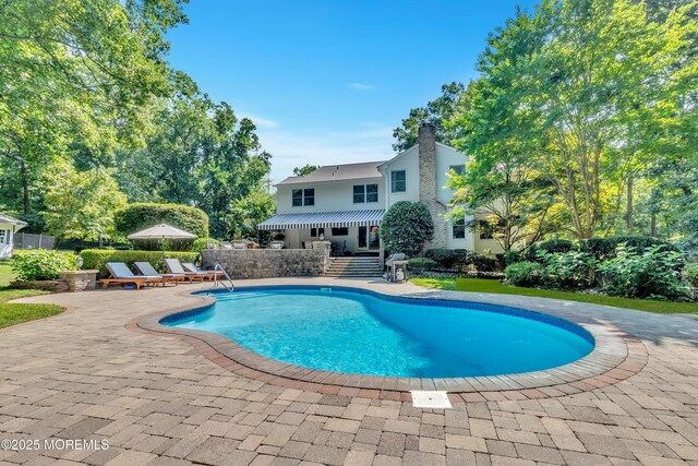 outdoor pool featuring fence and a patio