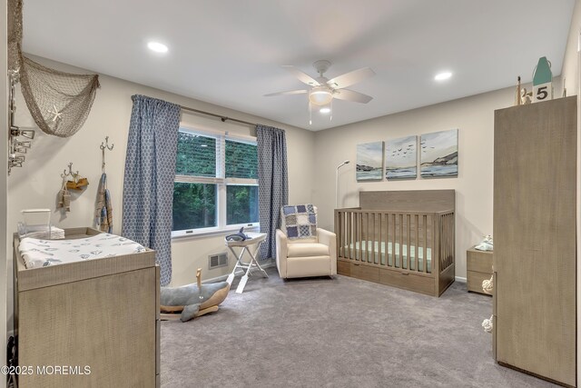 bedroom featuring a crib, carpet, recessed lighting, and visible vents