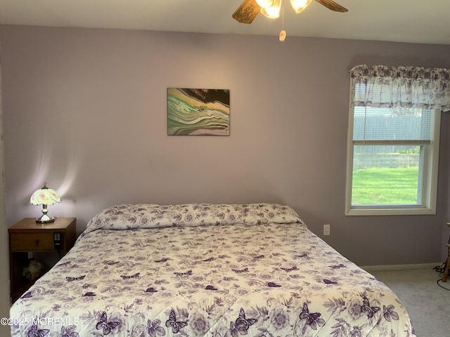 bedroom with baseboards, multiple windows, light carpet, and ceiling fan
