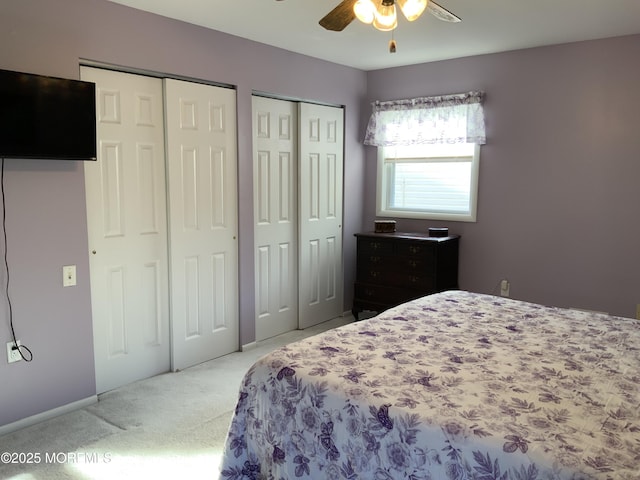 carpeted bedroom with two closets and ceiling fan