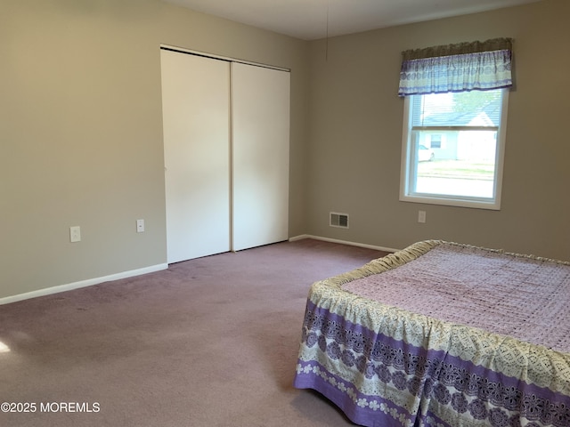 bedroom with a closet, baseboards, carpet flooring, and visible vents