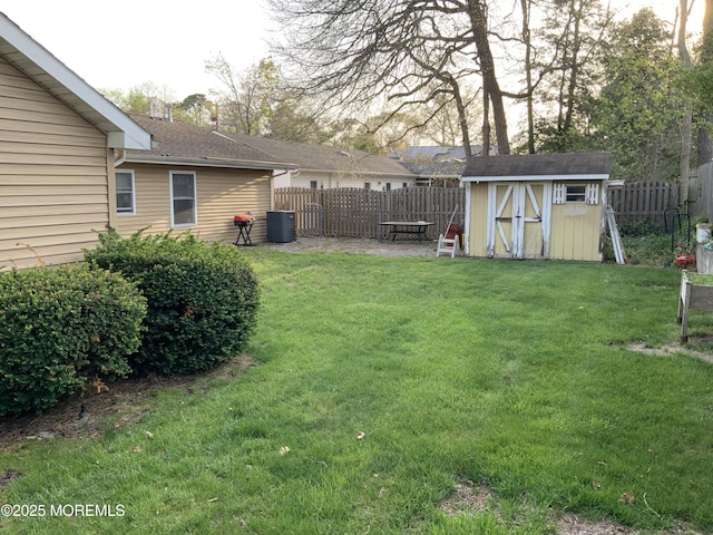 view of yard with a storage unit, a fenced backyard, and an outdoor structure