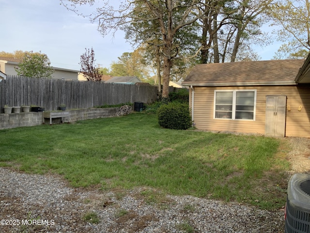 view of yard with central air condition unit and fence