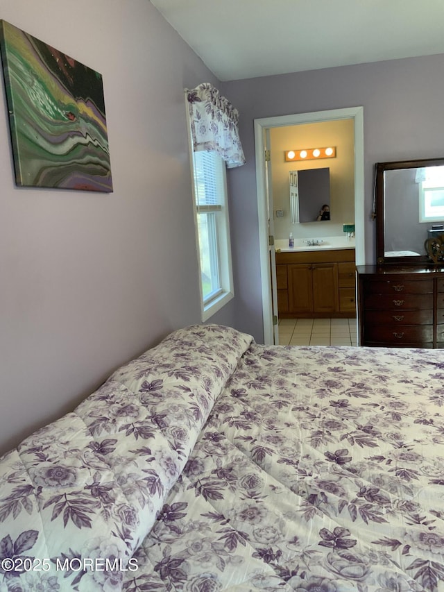 bedroom featuring a sink, light tile patterned flooring, and connected bathroom