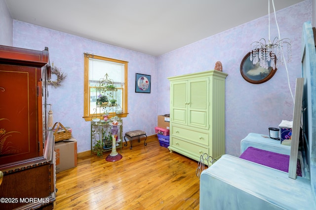 bedroom with wallpapered walls and light wood-type flooring