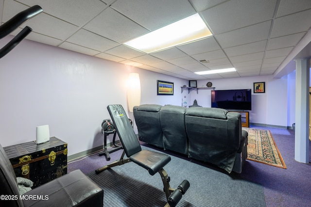 exercise room featuring baseboards, a drop ceiling, and carpet
