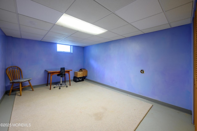 interior space featuring baseboards and a drop ceiling