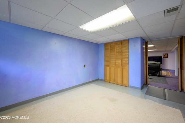 empty room with visible vents, a paneled ceiling, and baseboards