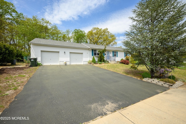 single story home with an attached garage and aphalt driveway