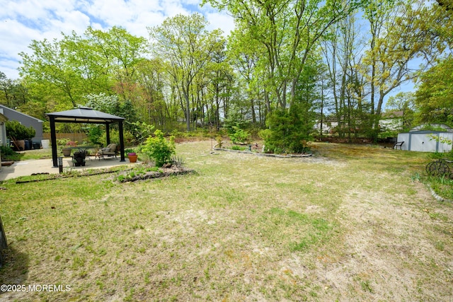 view of yard featuring an outbuilding, a gazebo, and a patio area