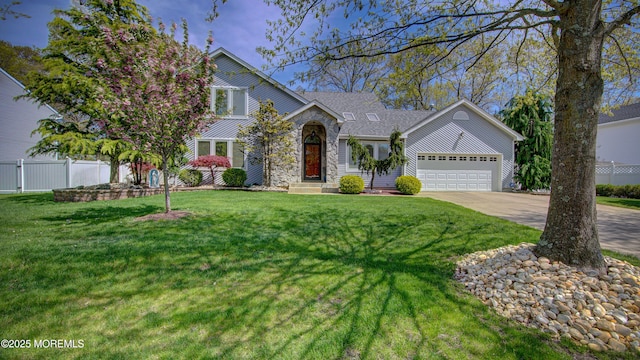 view of front of house with a garage, fence, a front lawn, concrete driveway, and stone siding