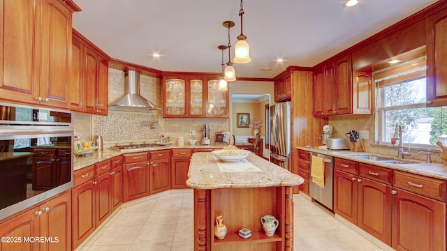 kitchen with a sink, decorative backsplash, stainless steel appliances, and wall chimney exhaust hood
