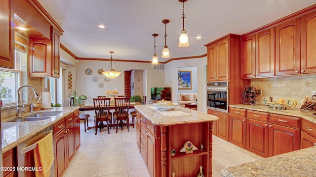 kitchen with backsplash, hanging light fixtures, light stone countertops, a sink, and stainless steel appliances