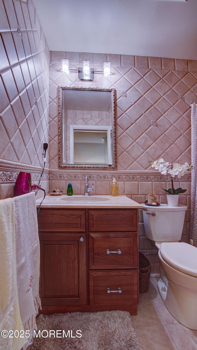 bathroom with vanity, toilet, and tile walls
