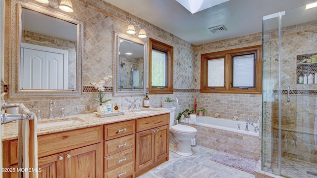 full bath featuring a sink, tile walls, double vanity, and visible vents