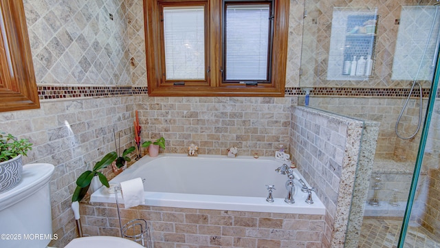 bathroom featuring a bath, toilet, tiled shower, and tile walls