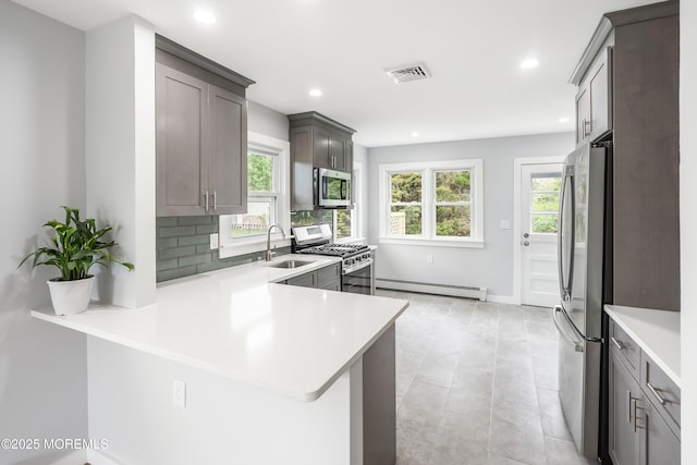 82 Fox Glove, Toms River, NJ 08755 - kitchen featuring a sink, baseboard heating, light countertops, appliances with stainless steel finishes, and decorative backsplash