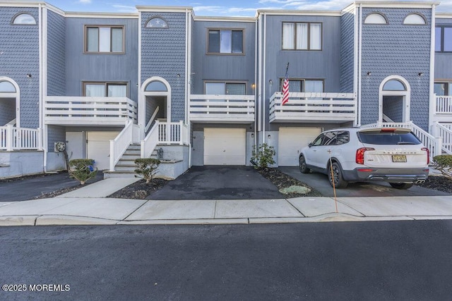 multi unit property featuring an attached garage and driveway