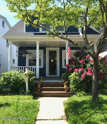 doorway to property featuring a shingled roof and covered porch