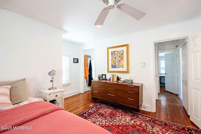 bedroom with a ceiling fan, baseboards, dark wood-style floors, and multiple windows