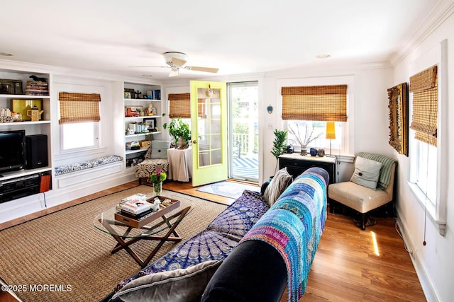 living room with crown molding, a ceiling fan, a healthy amount of sunlight, and wood finished floors