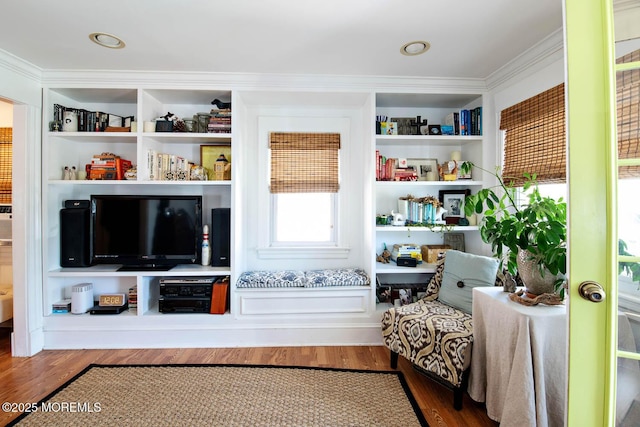 living area with crown molding and wood finished floors