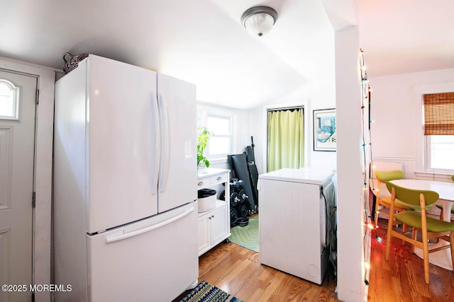 clothes washing area with plenty of natural light and light wood-type flooring