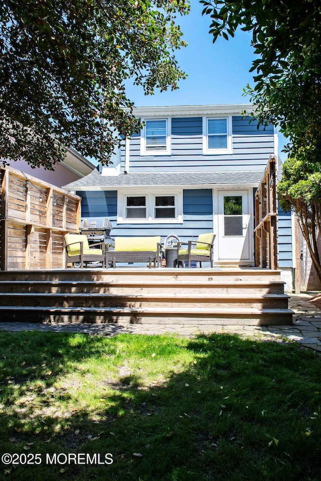 rear view of house with a lawn and a wooden deck