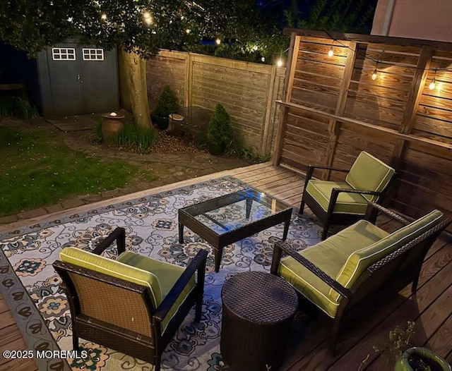view of patio featuring fence, an outbuilding, an outdoor hangout area, and a storage unit
