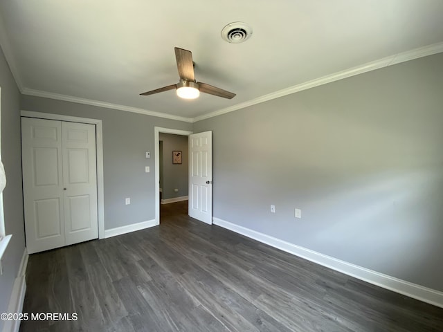 unfurnished bedroom with crown molding, baseboards, dark wood-type flooring, and visible vents