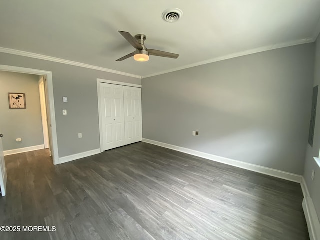 unfurnished bedroom featuring visible vents, ornamental molding, baseboards, and dark wood-style floors
