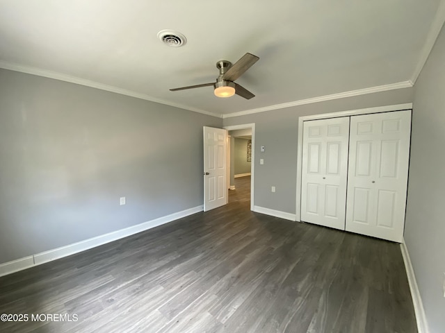 unfurnished bedroom featuring baseboards, visible vents, dark wood-style floors, and ornamental molding