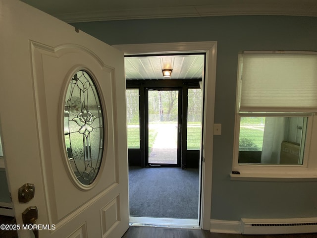 entryway with crown molding, baseboards, dark wood-type flooring, and baseboard heating