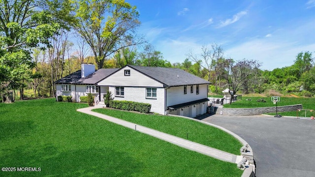 115 Phalanx Rd, Colts Neck, NJ 07722 - view of front of house with aphalt driveway, a chimney, a front yard, and a garage