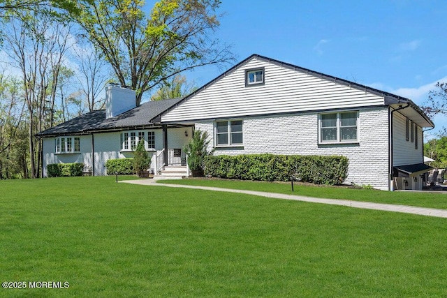 115 Phalanx Rd, Colts Neck, NJ 07722 - view of front of house with a chimney, brick siding, and a front yard