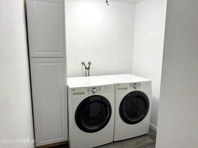 clothes washing area featuring wood finished floors, baseboards, cabinet space, and washer and dryer