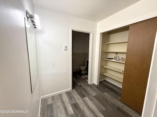 interior space with dark wood-type flooring and baseboards
