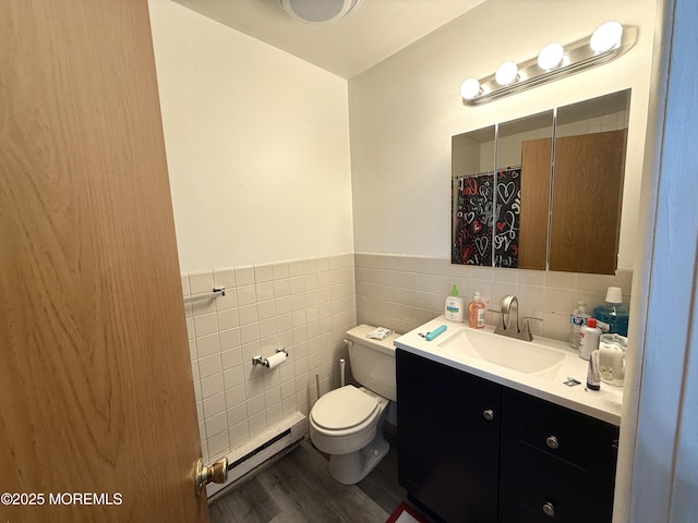 full bathroom with vanity, wood finished floors, toilet, tile walls, and a baseboard radiator
