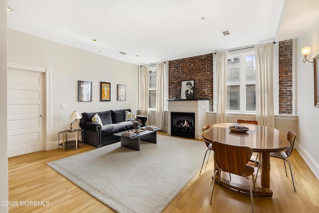 living area featuring wood finished floors, a fireplace, and baseboards