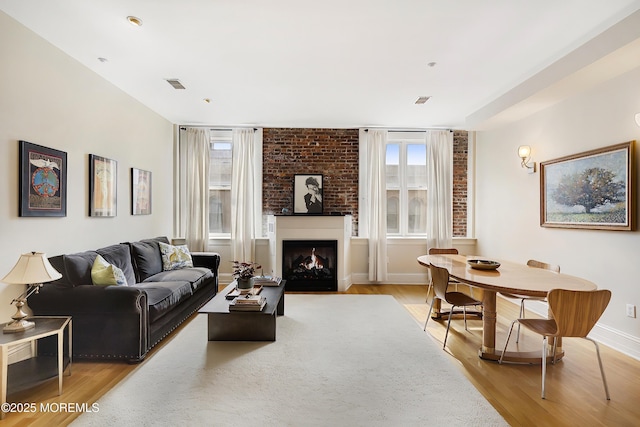 living room with light wood-style floors, baseboards, and a fireplace