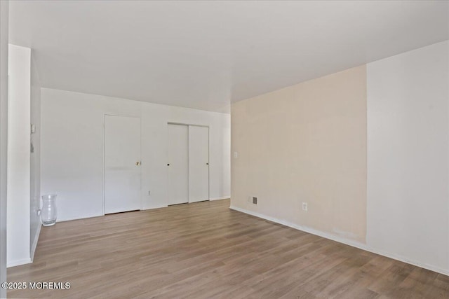 interior space with baseboards and light wood-type flooring