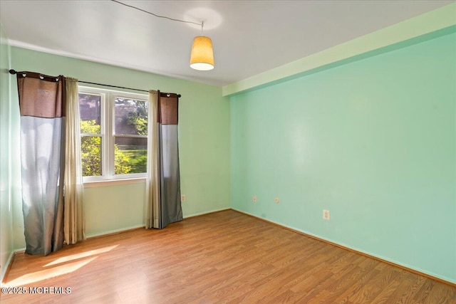 unfurnished room featuring light wood-type flooring and baseboards