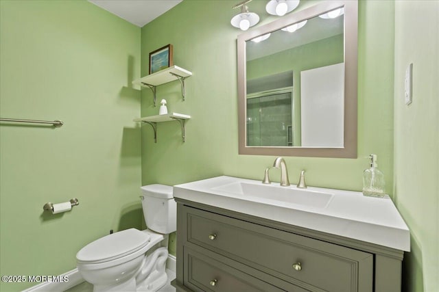 bathroom featuring vanity, toilet, and an enclosed shower