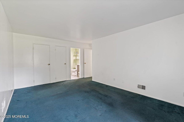 carpeted spare room featuring visible vents