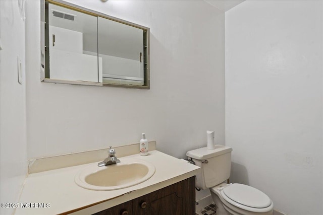bathroom with toilet, visible vents, and vanity