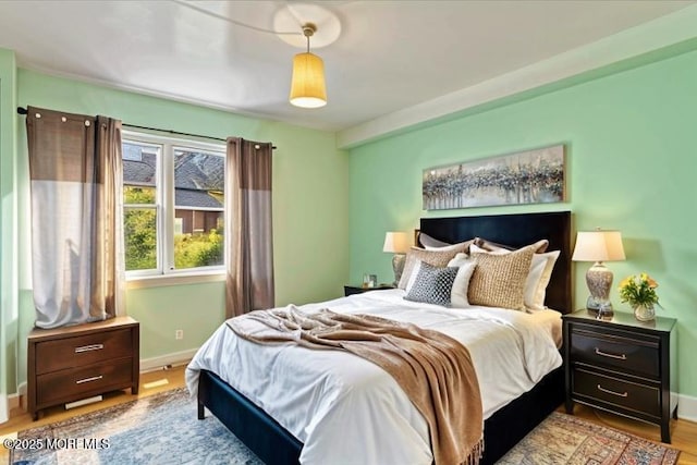 bedroom featuring baseboards and wood finished floors