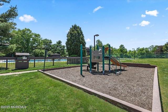 community play area with a yard and fence