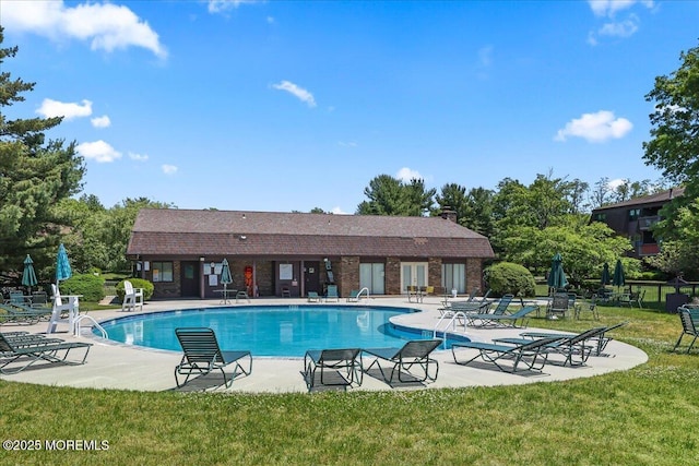 community pool featuring a yard, fence, and a patio