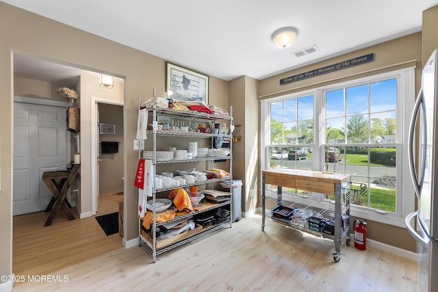 interior space with baseboards, visible vents, and wood finished floors